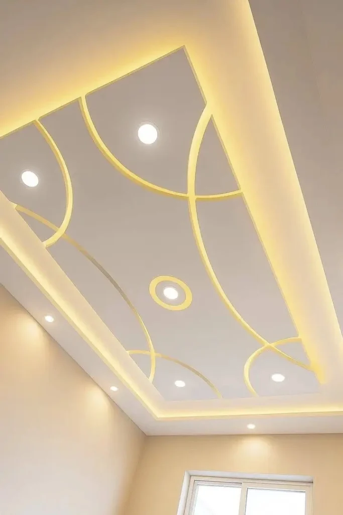 سقف جبس بورد بتصميم منحني، باللون الأبيض، مزوّد بإضاءة LED مخفية بلون أصفر تتبع الخطوط الدائرية